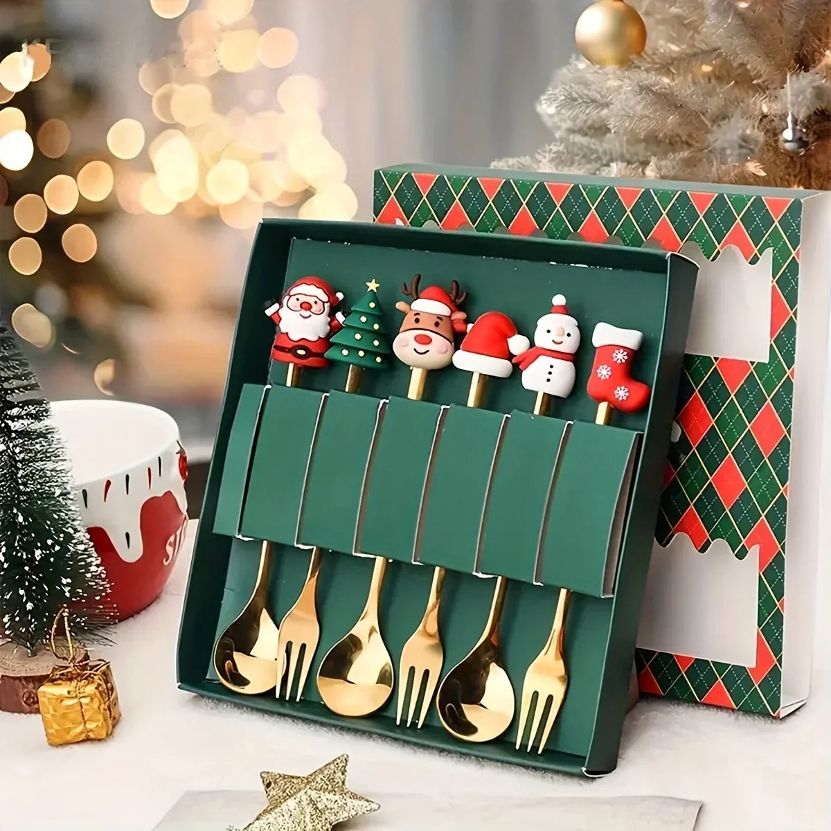 Set of gold Christmas-themed spoons in a decorative box with festive background